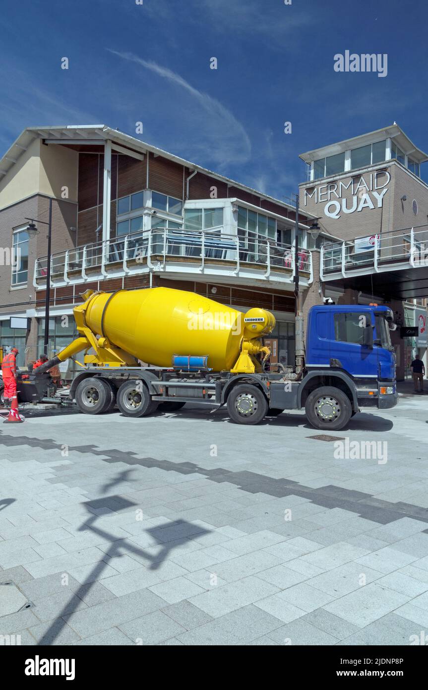 Gelber Transportbetonwagen, der am Mermaid Quay in Cardiff Bay arbeitet, Sommer 2022 Stockfoto