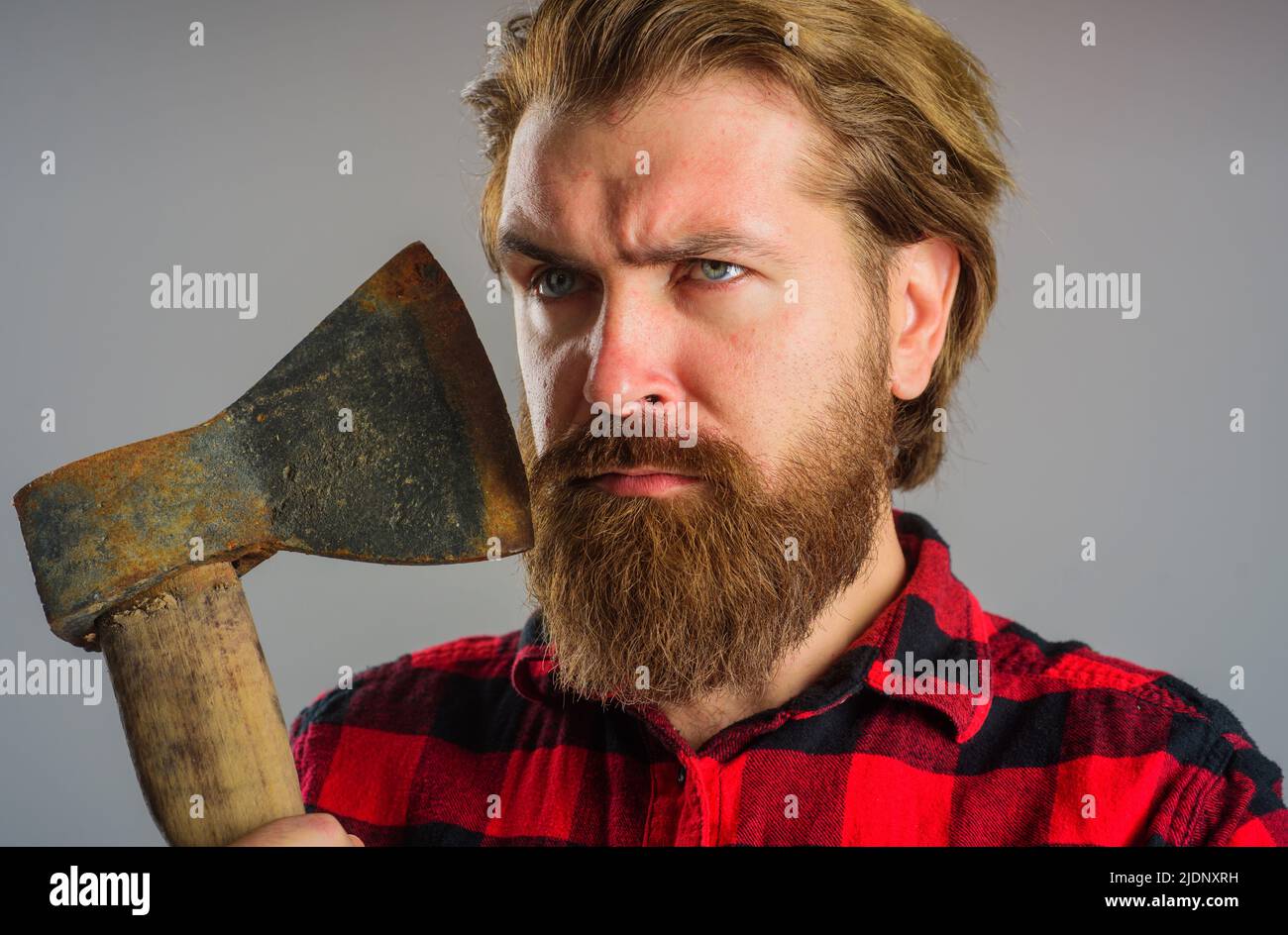 Ernsthafter bärtiger Mann mit Beil. Kanadischer Holzfäller mit alter Axt. Schneiden von Holz. Logger-Tools. Stockfoto