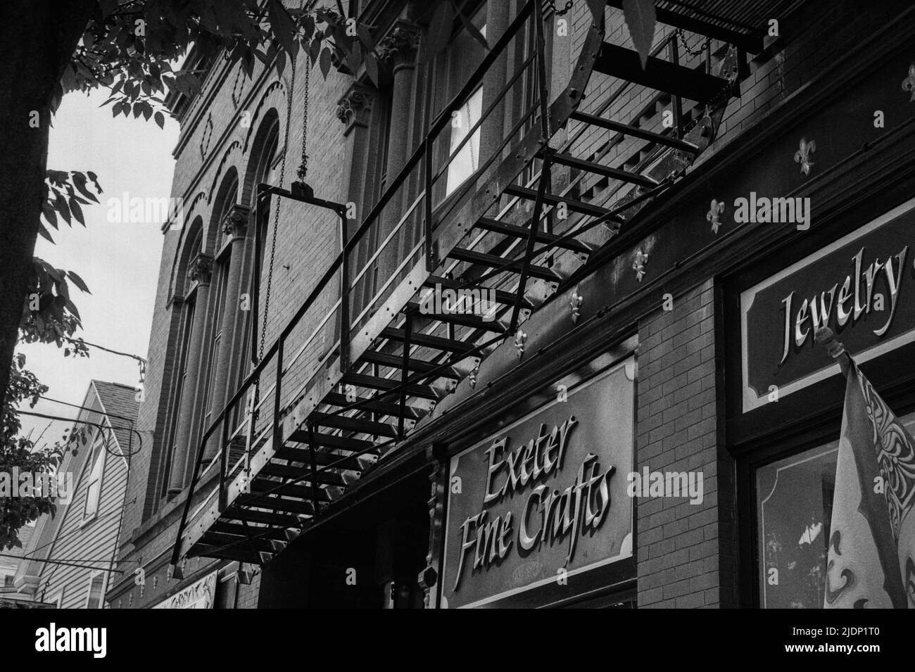 Blick auf einen alten Notausflucht an der Seite eines alten Backsteingebäudes in der Water Street in Exeter. Bild auf analogem Schwarzweiß-Film aufgenommen. Exeter, Stockfoto