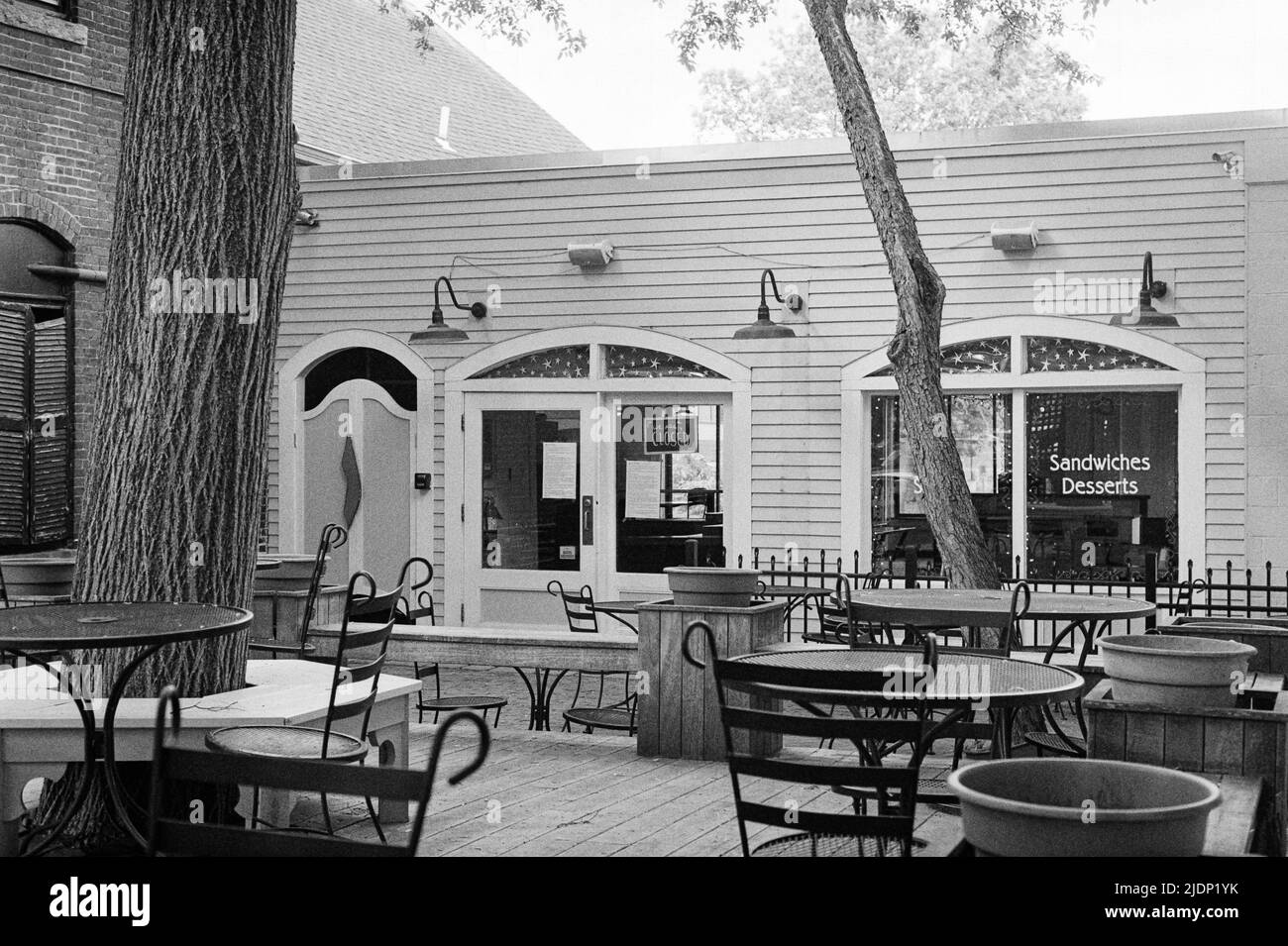 Eine entspannende, geschlossene Holzterrasse mit Tischen und Stühlen vor einem Restaurant an der Water Street in Exeter. Bild aufgenommen auf analogem Schwarzweiß-Fi-System Stockfoto