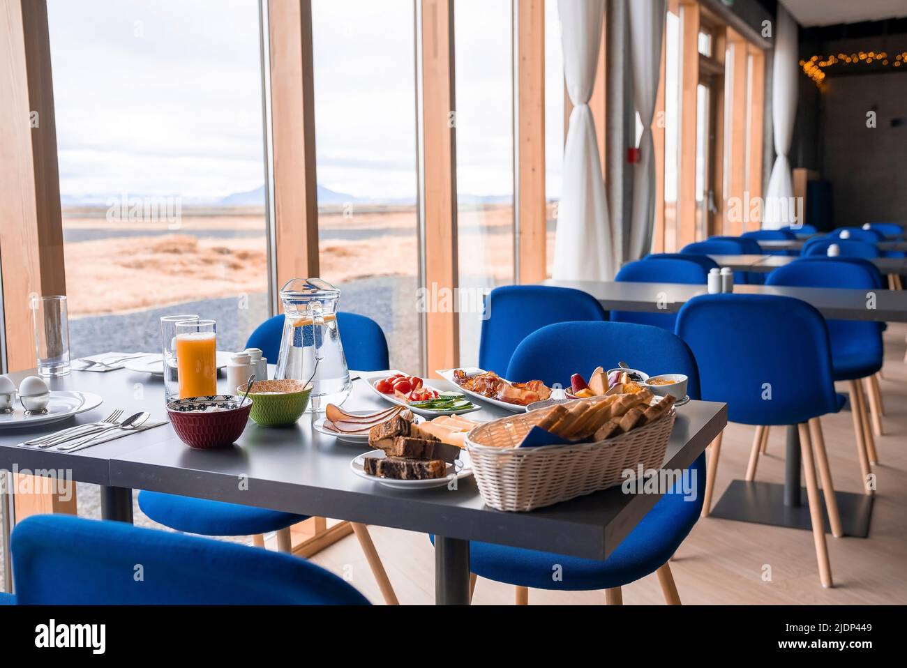 Im luxuriösen Restaurant wird ein köstliches Frühstück am Esstisch am Fenster serviert Stockfoto