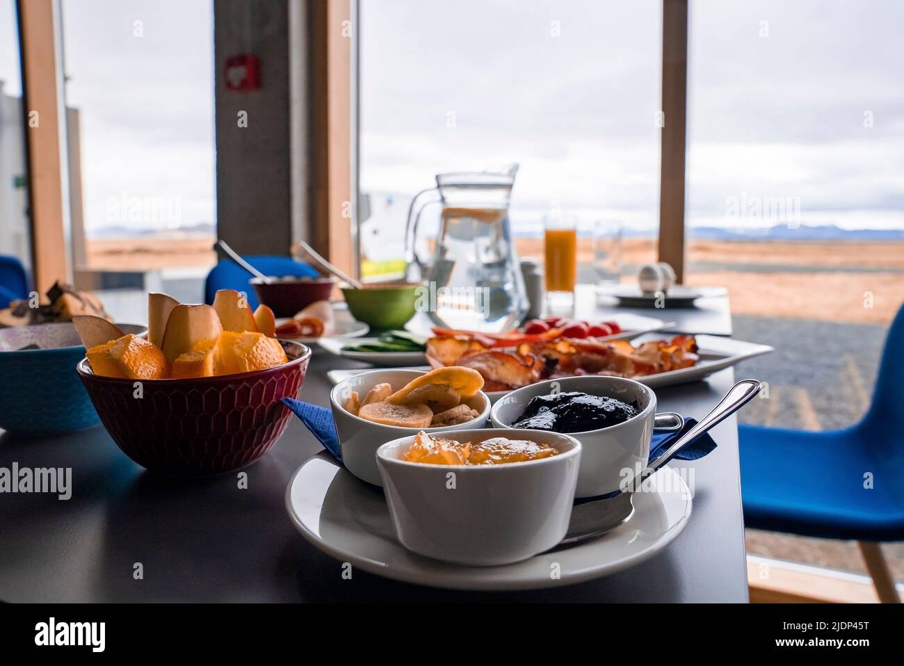 Das nahrhafte Frühstück wird am Tisch vor dem Fenster mit Blick auf das luxuriöse Hotel serviert Stockfoto