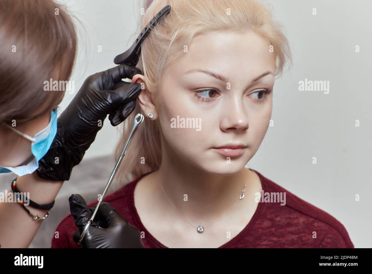 piercings auf dem Ohr. Muschel- und Helix-Piercings aus der Nähe. Professionell halten das Juwel Stockfoto