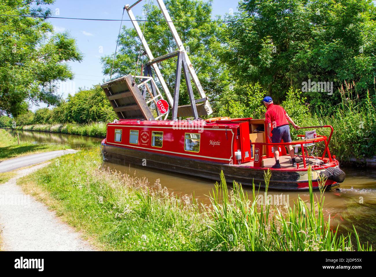 Ein Mann, der ein Schmalboot über die Liftbrücke von Morris auf dem Prees-Zweig des Llangollen-Kanals bei Whixall Moss bei Whitchurch England steuert Stockfoto