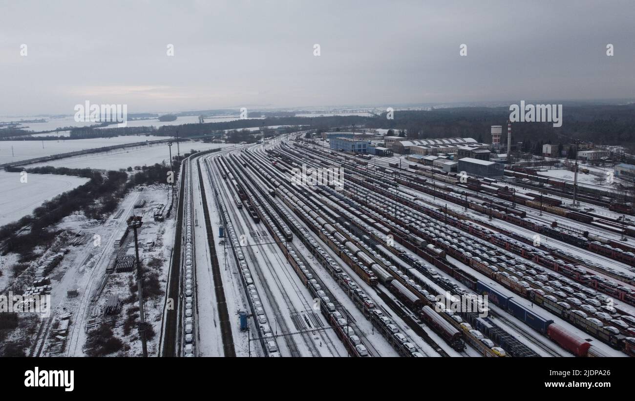Bahnhof unter Schneedecke Luftpanorama Landschaft Ansicht, Güterzüge mit Skoda Autos beladen, die von der Fabrik zu Kunden Stockfoto