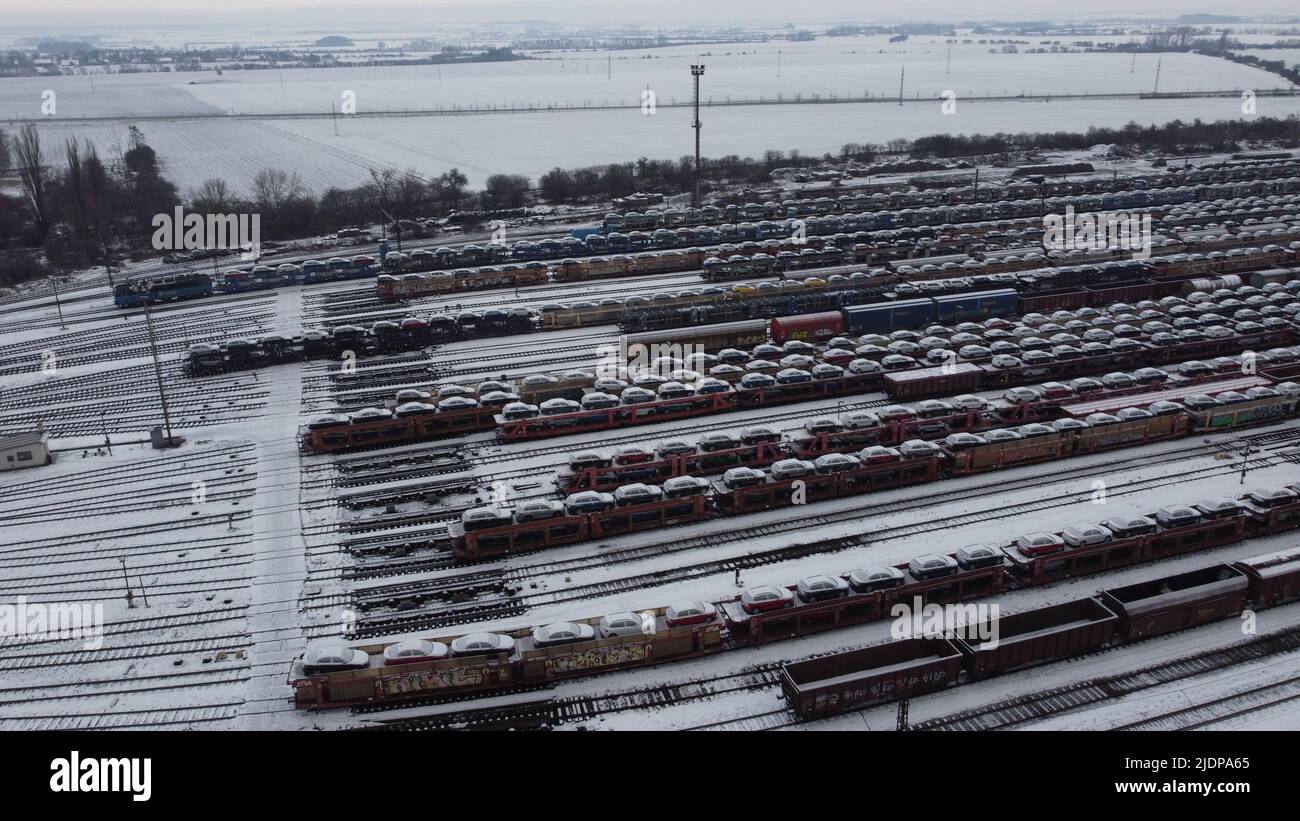 Bahnhof unter Schneedecke Luftpanorama Landschaft Ansicht, Güterzüge mit Skoda Autos beladen, die von der Fabrik zu Kunden Stockfoto