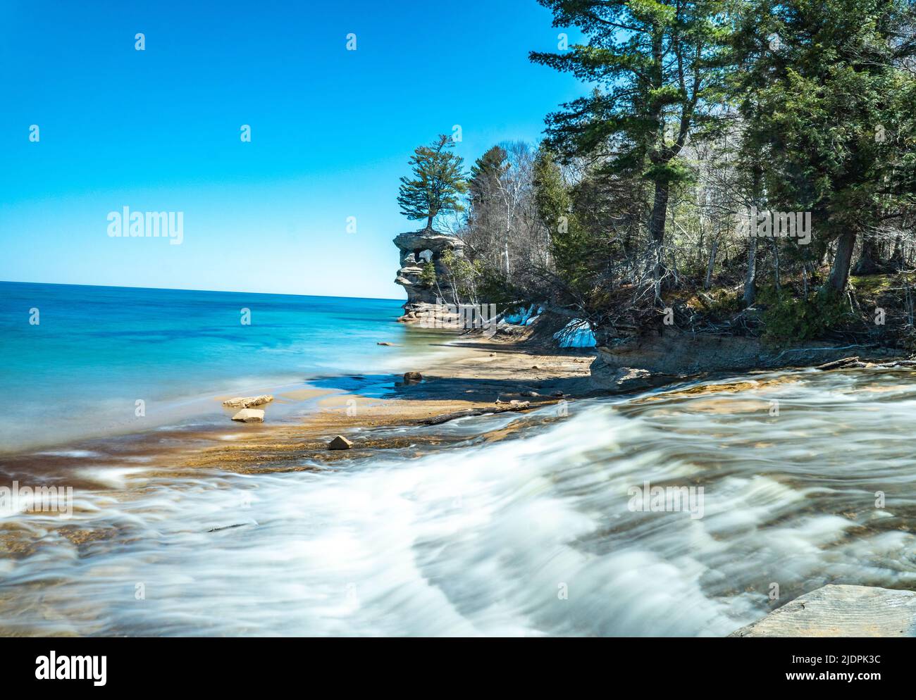 Eine Landschaft eines Flusses, der in Lake Superior fließt, mit Chapel Rock im Hintergrund der Pictured Rocks National Shoreline Stockfoto