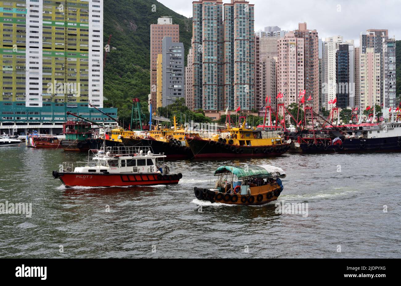 Ein kleines Sampan-Boot wird vom Marine Pilot Boot begleitet, um den Hafen in Hongkong zu verlassen Stockfoto