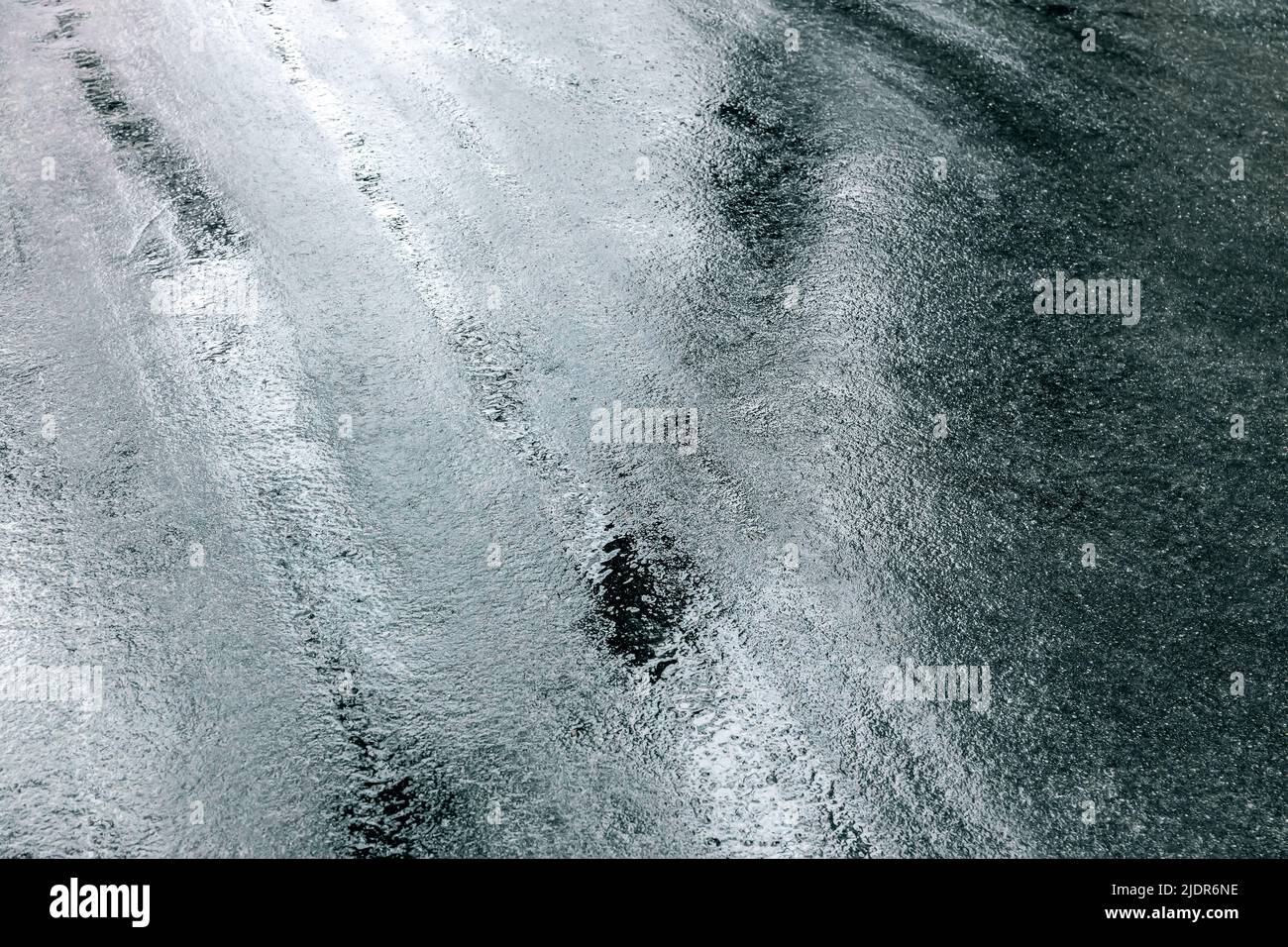 Raue Textur der nassen dunklen Bürgersteig nach Regen. Nass Asphalt Straße Hintergrund. Stockfoto