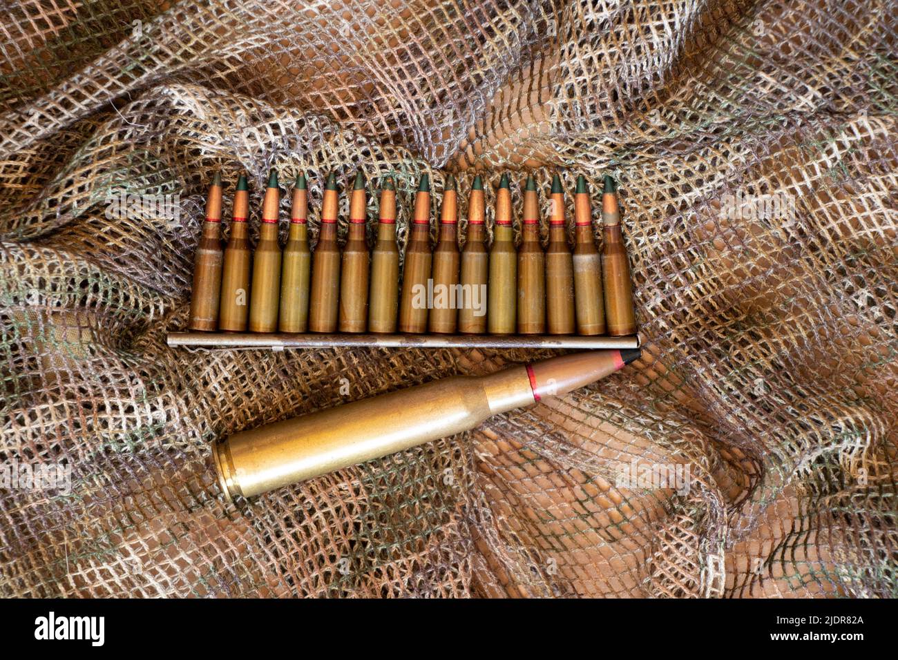 Kugeln liegen auf einem grünen Tarnhintergrund, Militärwaffen, Munitionsdepot Stockfoto