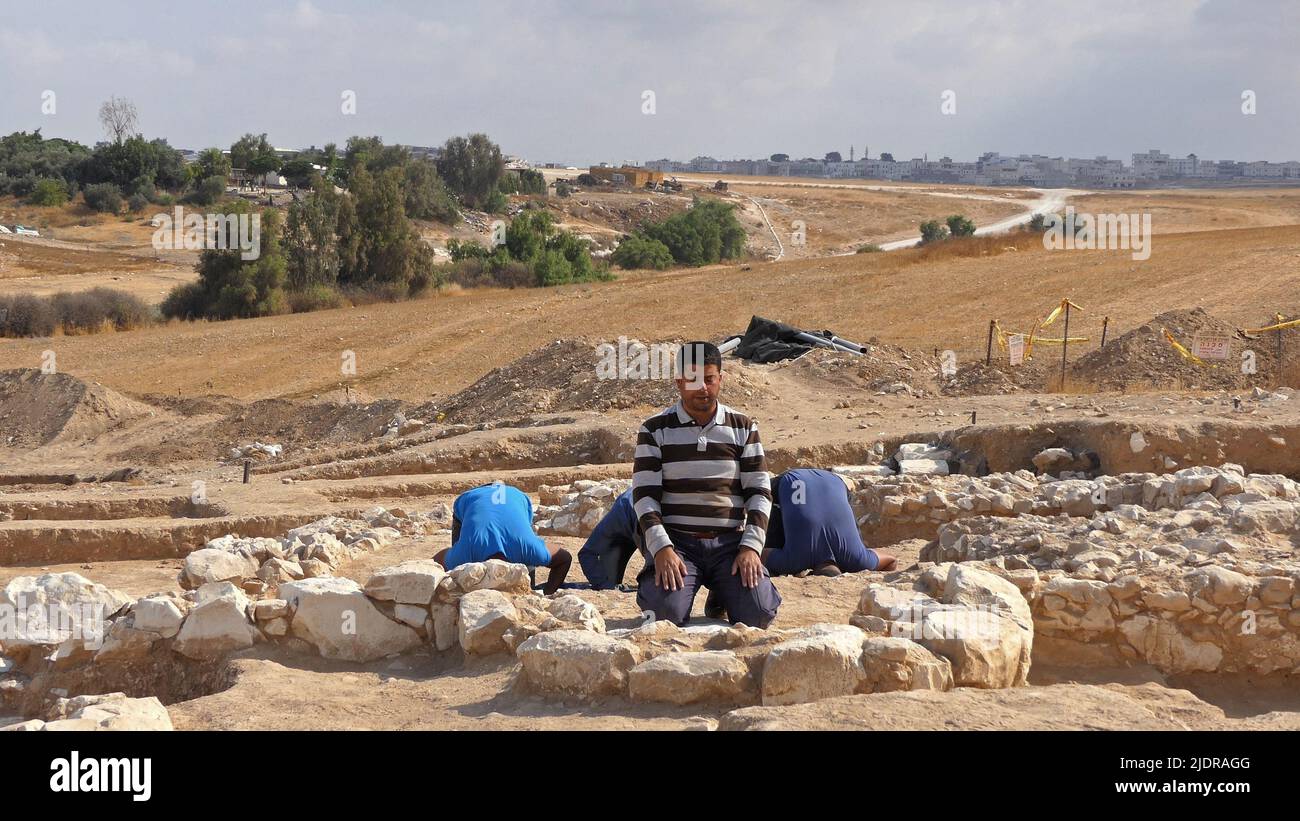 RAHAT, ISRAEL - 22. JUNI: Palästinensische Arbeiter der israelischen Antikenbehörde beten am 22. Juni 2022 in Rahat, Israel, inmitten der Überreste einer kürzlich entdeckten Moschee, die zu den ältesten weltweit bekannten (über 1200 Jahre alt) gehört. Große archäologische Ausgrabungen, die von Israel im Rahmen eines Plans zur Erweiterung der Beduinenstadt Rahat durchgeführt wurden, liefern grafische Details des religiösen Übergangs vom Christentum zum Islam im siebten bis neunten Jahrhundert. Kredit: Eddie Gerald/Alamy Live Nachrichten Stockfoto