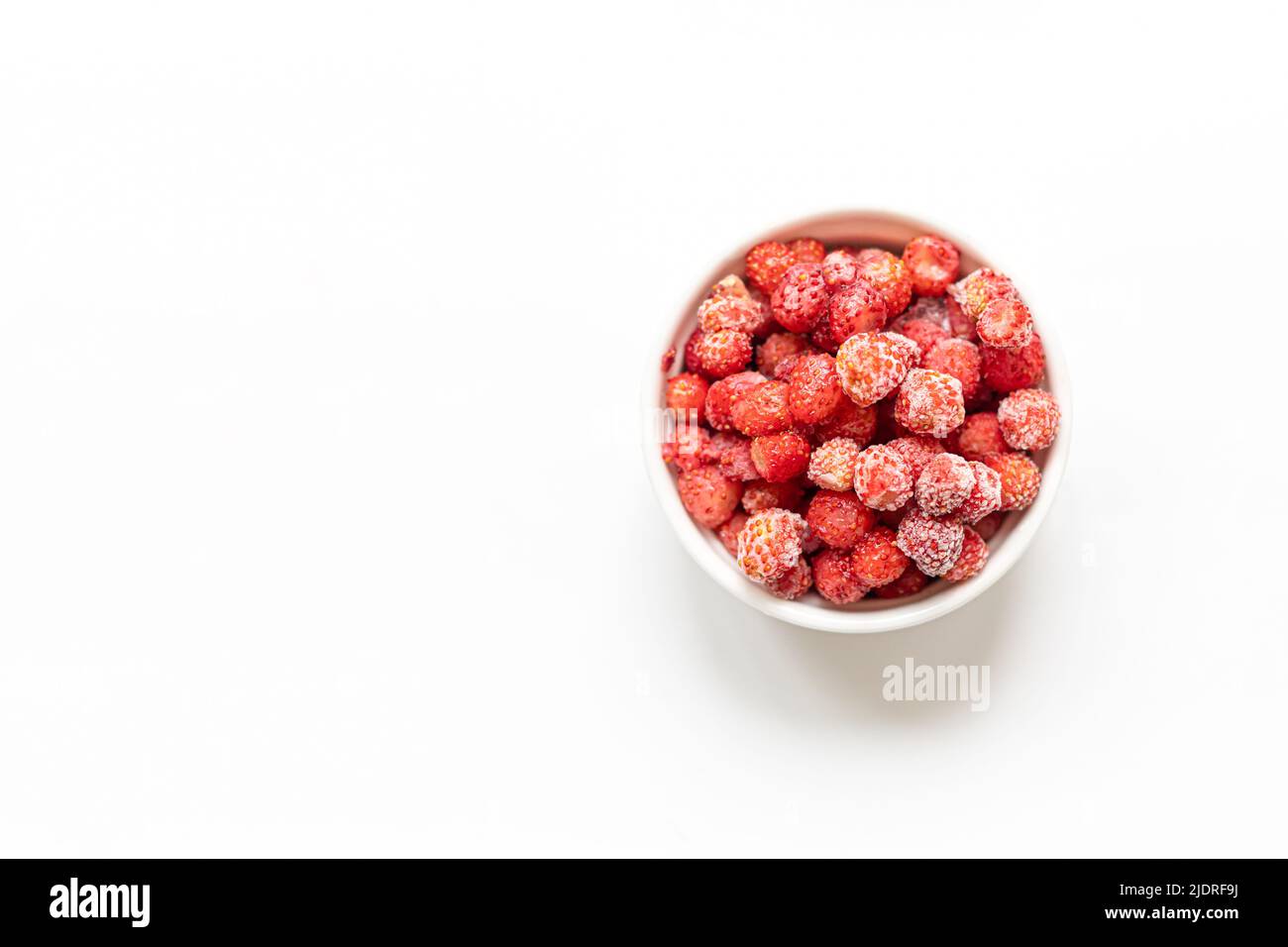 Gefrorene rote Waldbeeren in weißer Schale auf weißem Hintergrund mit Platz für Text. Einfrieren Beeren sind gesund, sie enthalten alle Vitamine Stockfoto