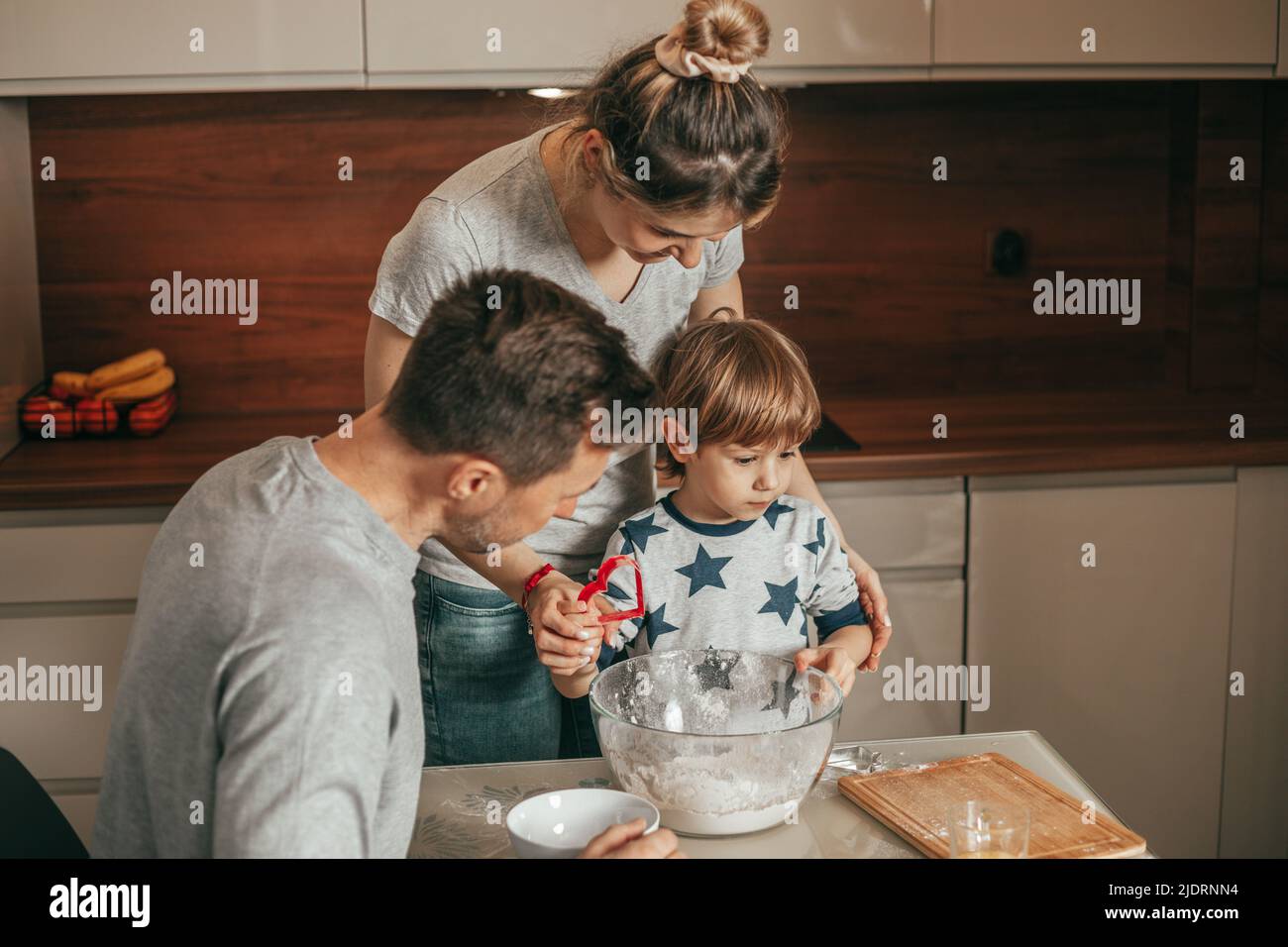 Mutter, Vater und Sohn bereiten sich auf die Backküche vor, Teamwork. Glückliche Stunden der jungen Familie, Vater Mutter und Kind, Eltern und Kind. Stockfoto