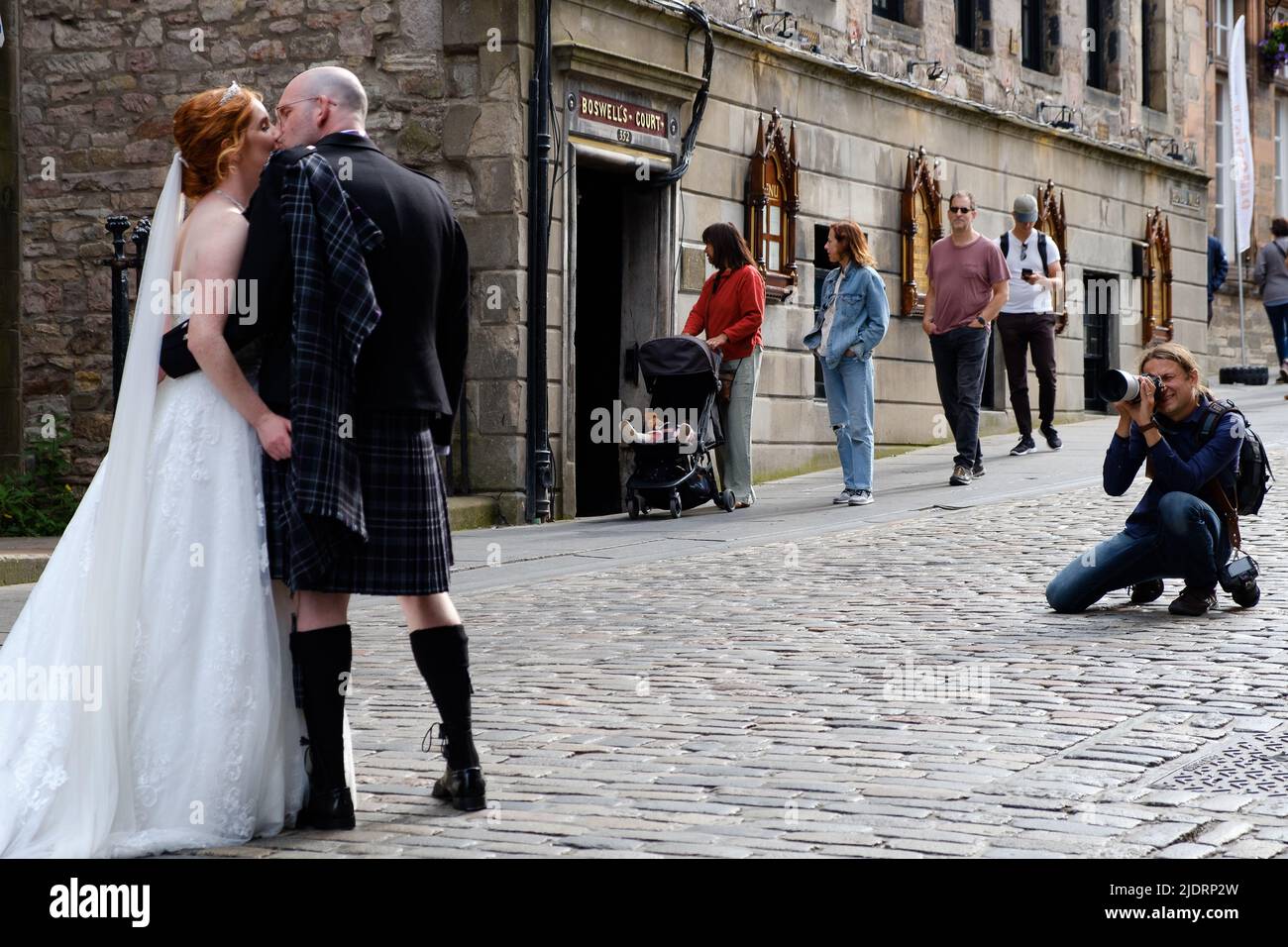 Hochzeitskuss - ein frisch verheiratetes Paar, das Hochzeitsfotos auf der Royal Mile in Edinburgh in der Nähe des Edinburgh Castle gemacht hat Stockfoto