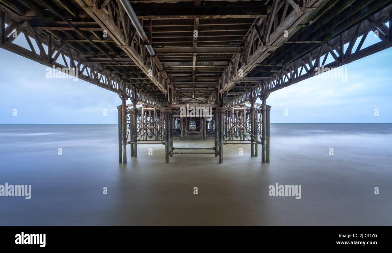 Langzeitbelichtung Fotografie fängt die Unterseite des Central Pier in Blackpool, Lancashire, Großbritannien bei Flut mit dem Meer sieht glatt und verschwommen Stockfoto