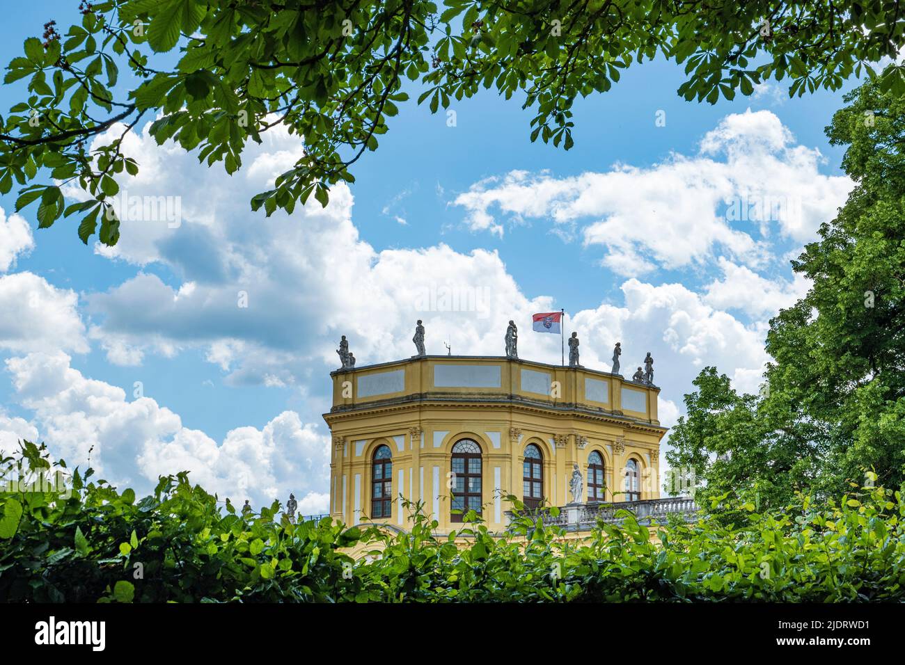 Teil der barocken Orangerie in Kassel, eingerahmt von grünen Hecken und Ästen Stockfoto