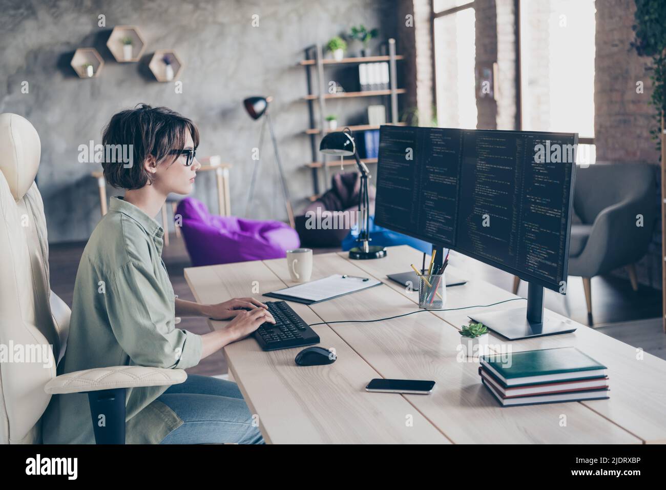 Profil Seitenansicht Porträt von attraktiven qualifizierten Mädchen unterstützen Manager Eingabe Text Code HTML Bedienung css am Arbeitsplatz Station drinnen Stockfoto