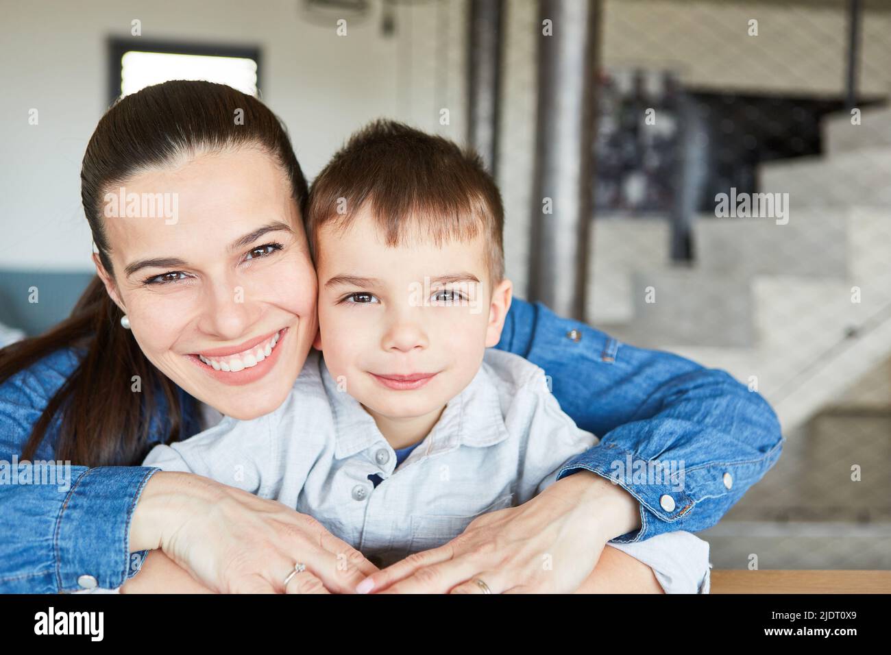 Glückliche Mutter und ihr Sohn zu Hause im Wohnzimmer für Nähe und Intimität Stockfoto