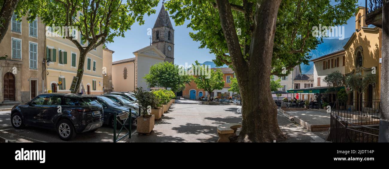 Panorama des Dorfplatzes eines Bergdorfes in den unteren Alpen der Provence, Frankreich mit Rathaus, Kirche und Restaurant. Stockfoto