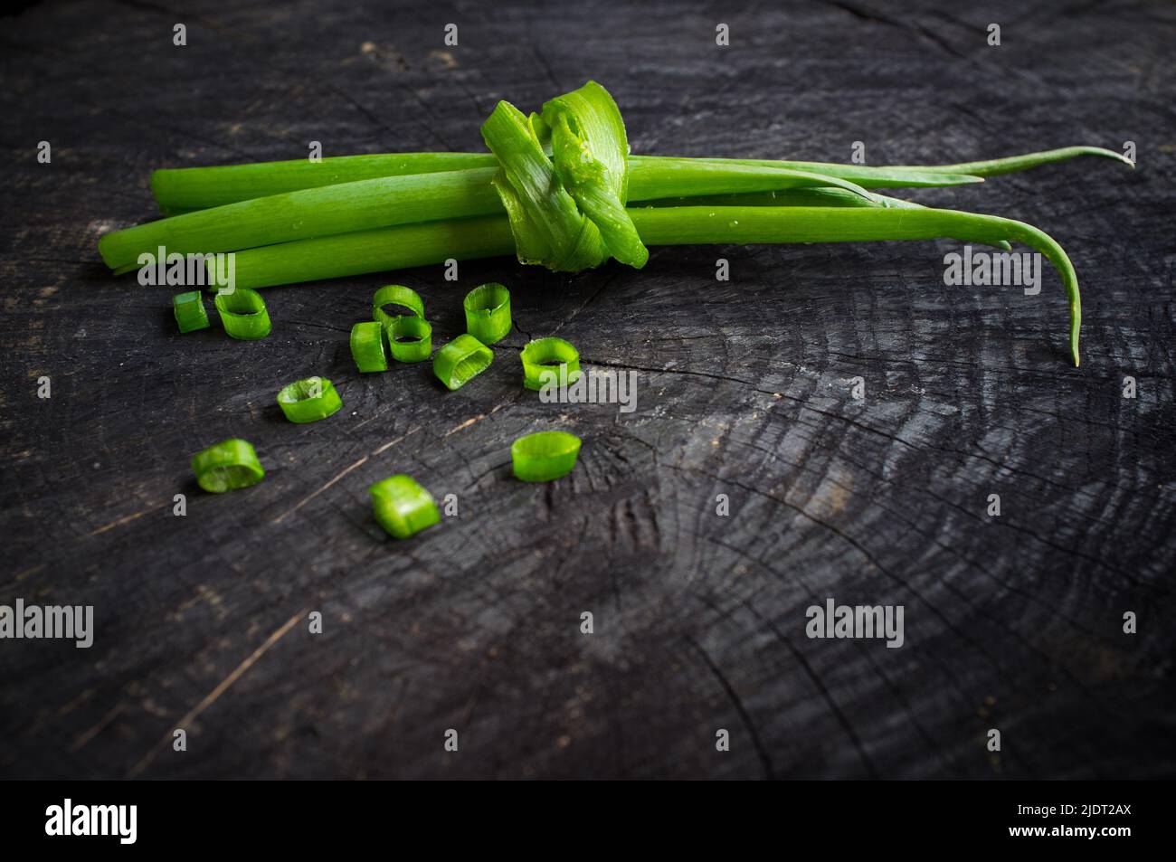 Bund von grünen Zwiebeln auf dem dunklen Hintergrund Stockfoto
