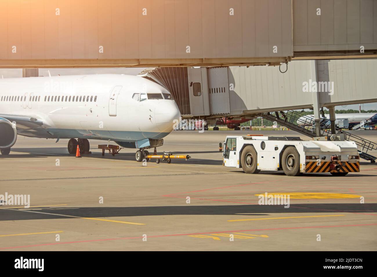 Abschleppwagen, der sich bereit zum Abschleppen des Flugzeugs zum Parkplatz am Flughafen befindet Stockfoto