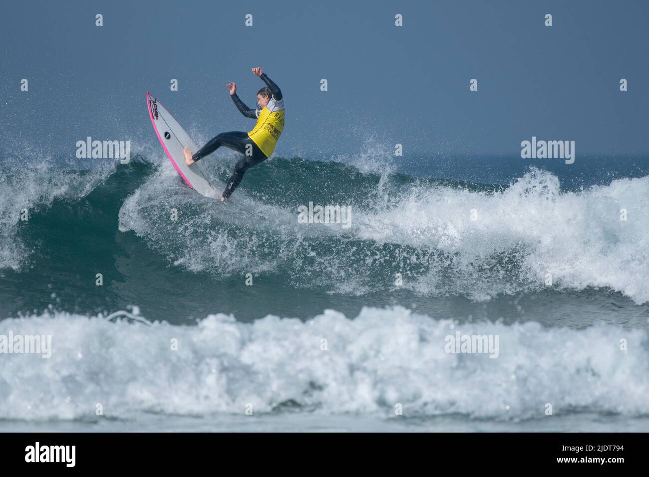 Ein männlicher Surfer, der an einem Surfwettbewerb im Fistral in Newquay in Cornwall in Großbritannien teilhat. Stockfoto