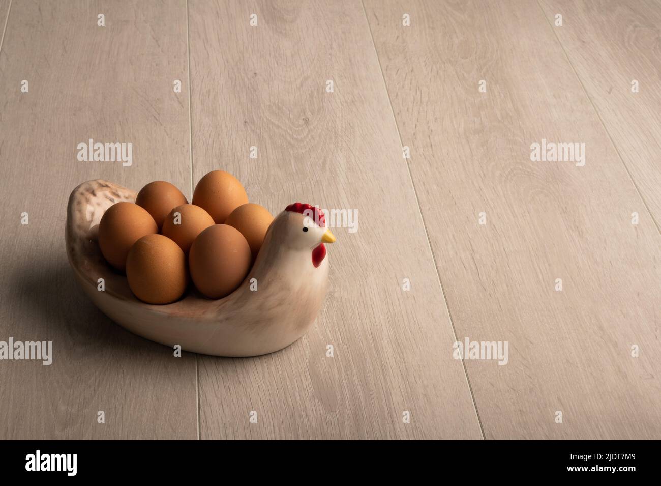 Hühnereier in einer Hühnerform auf einer hellen Holzoberfläche, mit negativem Platz für Kopien Stockfoto