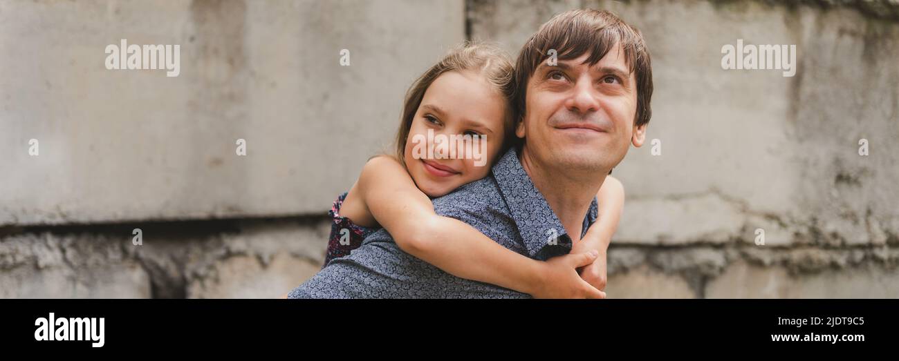 Mann Vater mit Qualität Zeit mit ihrem Kind Tochter Mädchen neun Jahre alt auf dem Rücken. Glücklicher Vater spielt mit Kind. Echtes Leben authentisches Tag-zu-Tag fa Stockfoto
