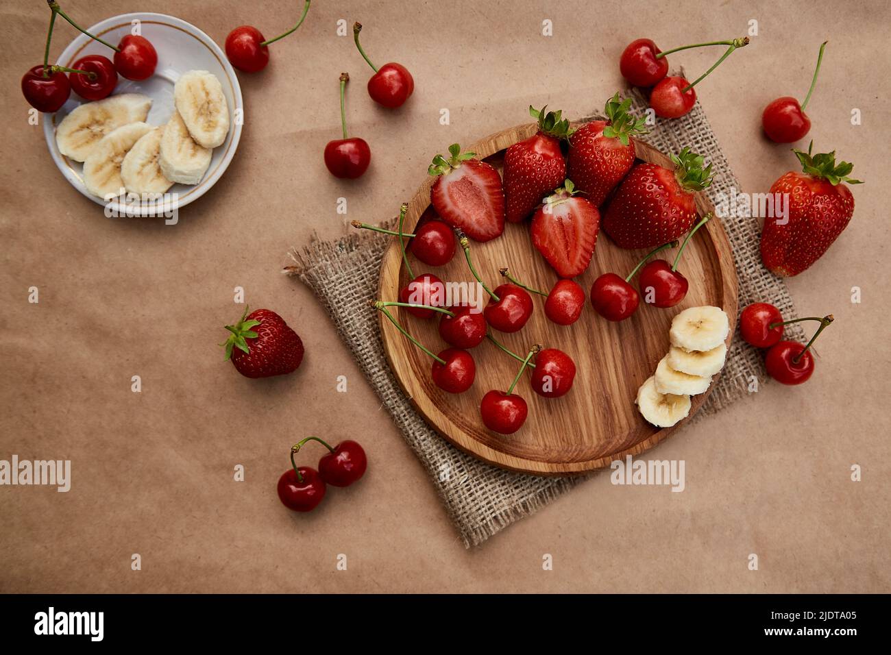 Frische Sommerfrüchte - Erdbeere, Banane und Kirsche flach legen. Sommervitamine, gesunde Ernährung. Stockfoto