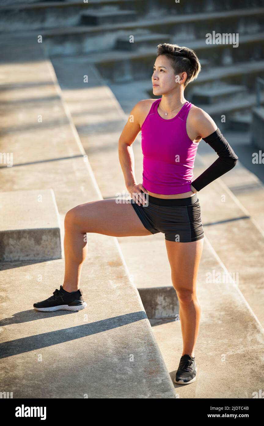 Sportliche Frau mit amputierter Hand, die auf Treppen steht Stockfoto