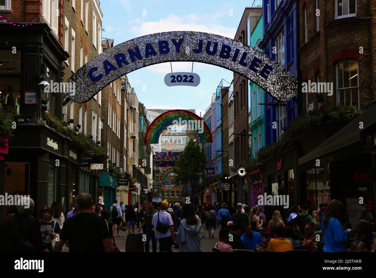 Carnaby Street London England Großbritannien mit einem Regenbogen für Schwulenstolz und einem Schild für das Carnaby Jubilee für das Platinum Jubilee im Juni 2022 Stockfoto