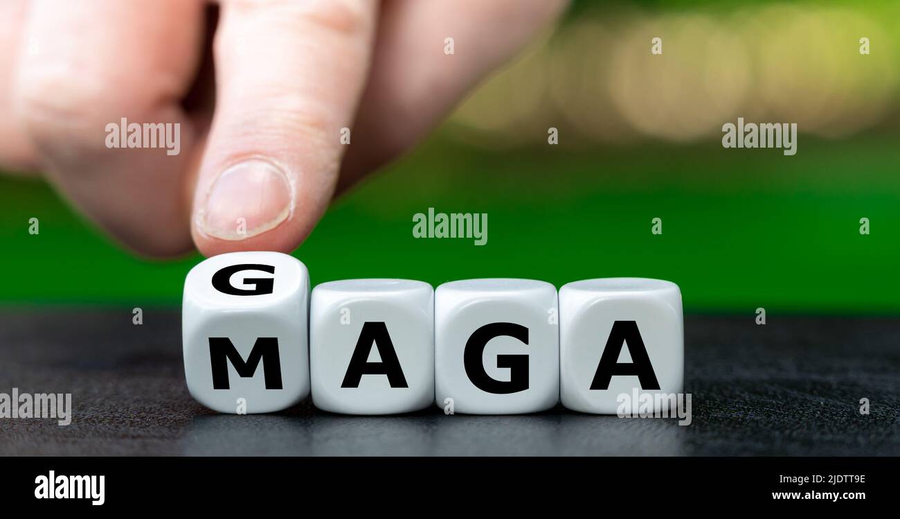 Symbol für den Slogan 'Make america great again' (MAGA). Die Hand dreht Würfel und ändert den Ausdruck „MAGA“ in „GAGA“. Stockfoto
