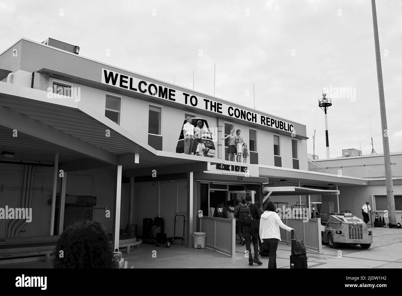 „Willkommen in der Conch Republic“ steht auf dem Schild auf dem Key West International Airport Gebäude, wenn Sie vom Asphalt aus eintreten. Gruppe von Schaufensterpuppen Stockfoto
