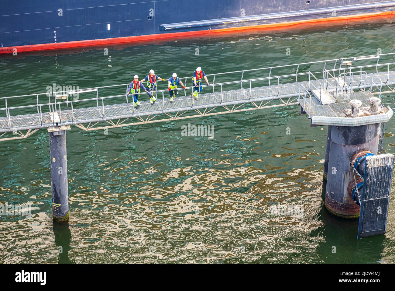 Arbeiter, die sich darauf vorbereiten, ein Luxuskreuzfahrtschiff im Hafen von Kiel, Schleswig-Holstein, anzudocken Stockfoto