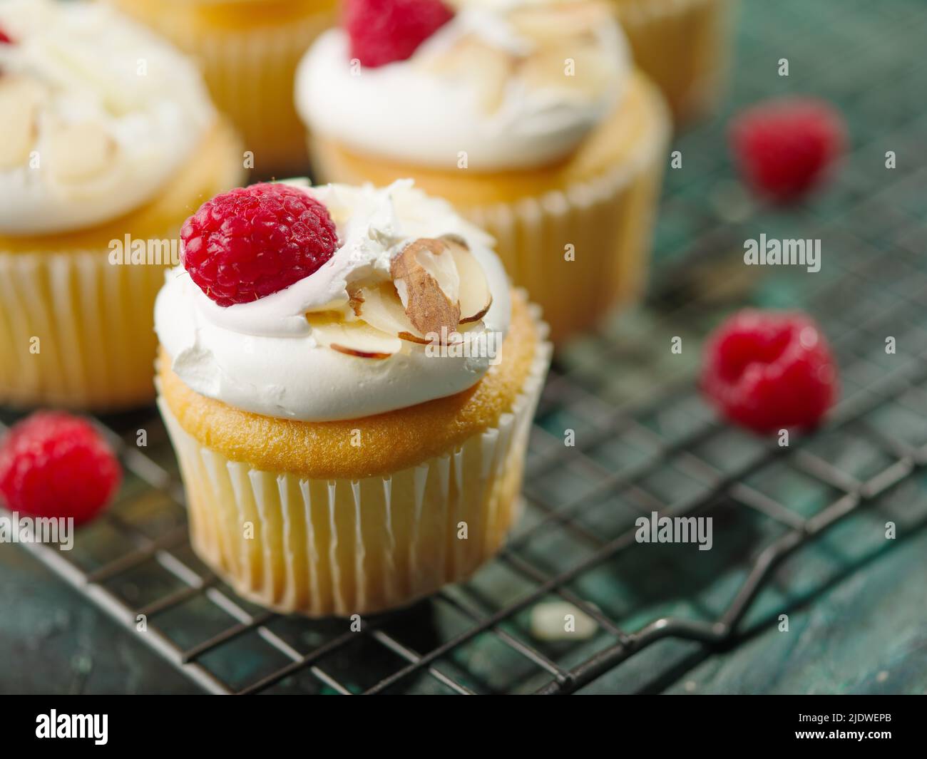 Wunderschön dekorierte Muffins mit Rahm, frischen Himbeeren und Mandeln. Festliche Leckerbissen zum Geburtstag, Bankett, Feiertag. Restaurant, Hotel, Cafe, Confec Stockfoto