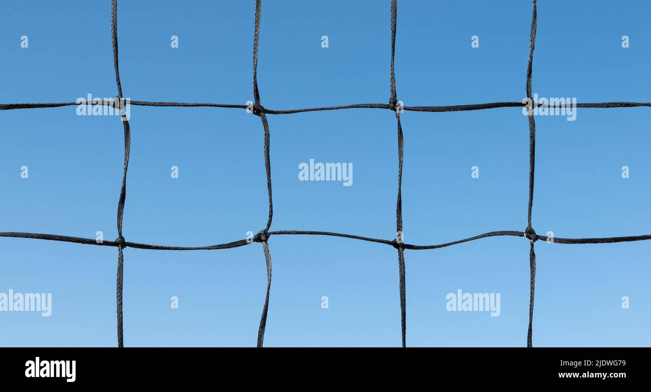 Volleyballnetz vor blauem Himmel Hintergrund. Stockfoto