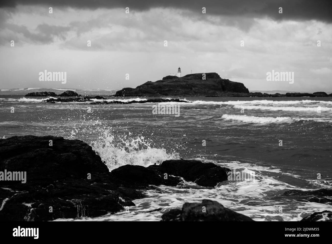 Meereswellen, Leuchtturm und Yellowcraig Beach, Schottland, in Schwarz und Weiß Stockfoto
