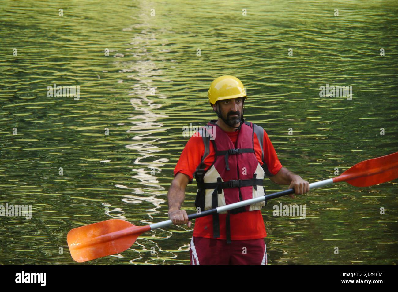 Adventure man paddelt mit einem Holzkanu im Meer Stockfoto