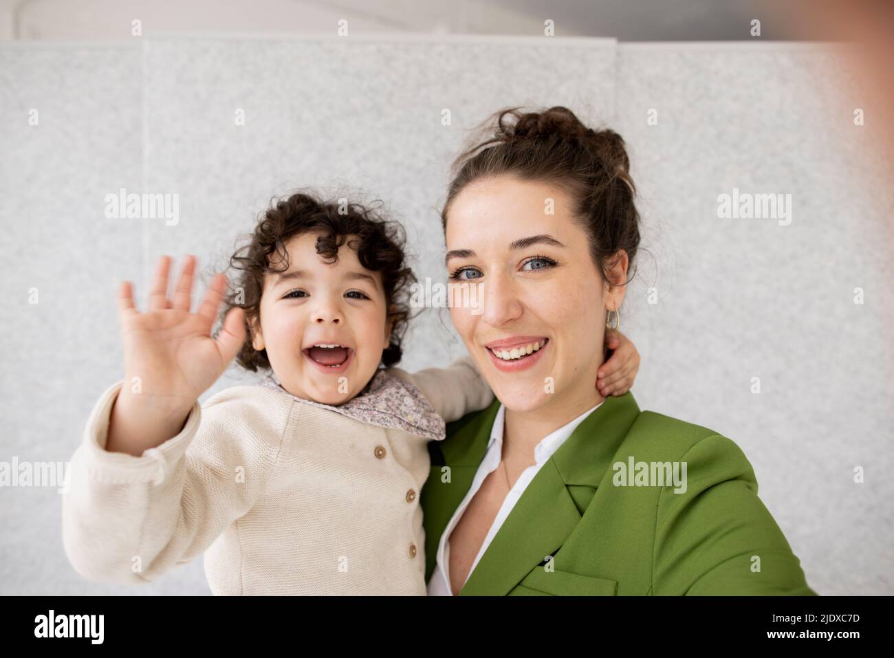 Glückliche Mutter und Tochter winken vor der Kamera Stockfoto
