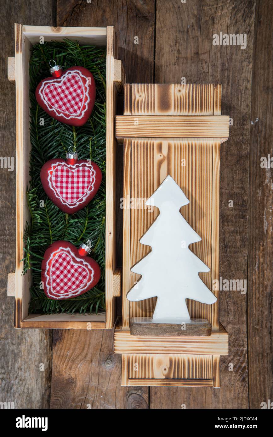 Weihnachtsschmuck in Kiste mit Nadelholzzweigen Stockfoto