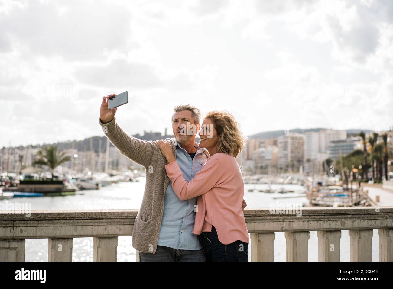 Reifer Mann nimmt Selfie mit Frau auf Smartphone im Urlaub Stockfoto