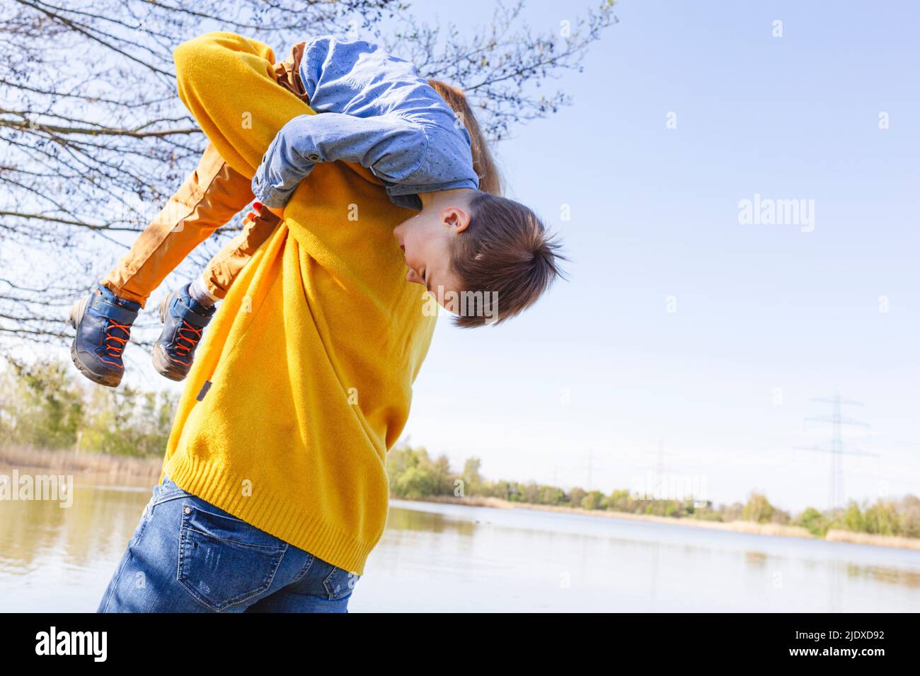 Mutter trägt Sohn auf der Schulter am See Stockfoto