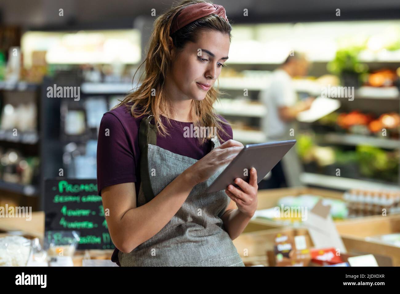 Ladenbesitzer, der Tablet-PC im Bio-Markt verwendet Stockfoto