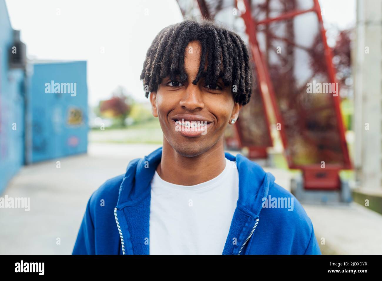 Glücklicher junger Mann mit locs, die Zahnspangen tragen Stockfoto