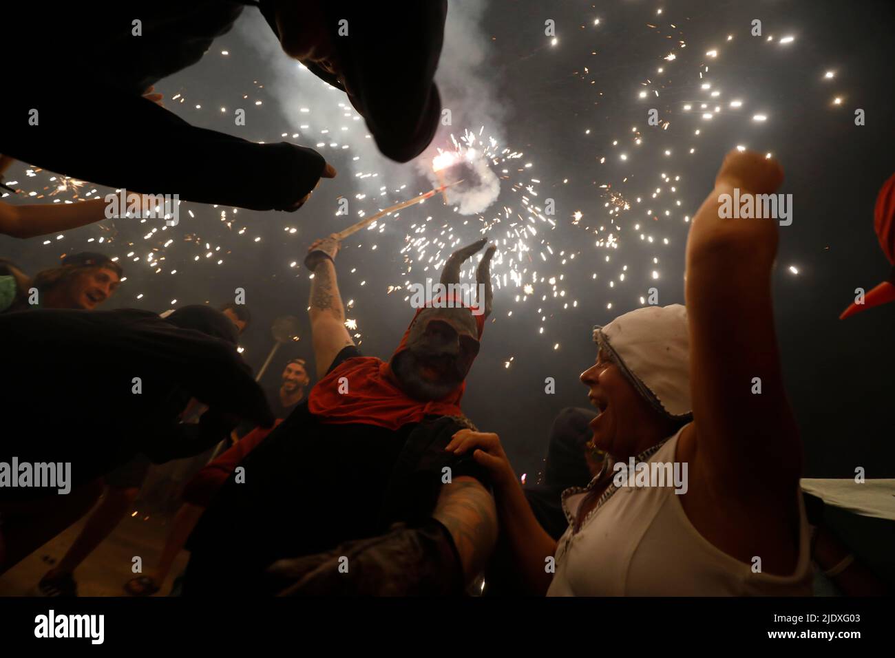 Palma, Spanien. 23.. Juni 2022. Beim traditionellen Correfoc am St. John's Eve tanzen Nachtschwärmer unter Menschen, die als Teufel gekleidet sind, während ein Feuerwerk ausgehüllt wird. Correfoc ist ein traditionelles Fest, bei dem sich Menschen, die als Teufel und „Feuertiere“ verkleidet sind, mit dem Publikum vermischen und zu Musik und Feuerwerk tanzen. Quelle: Clara Margais/dpa/Alamy Live News Stockfoto