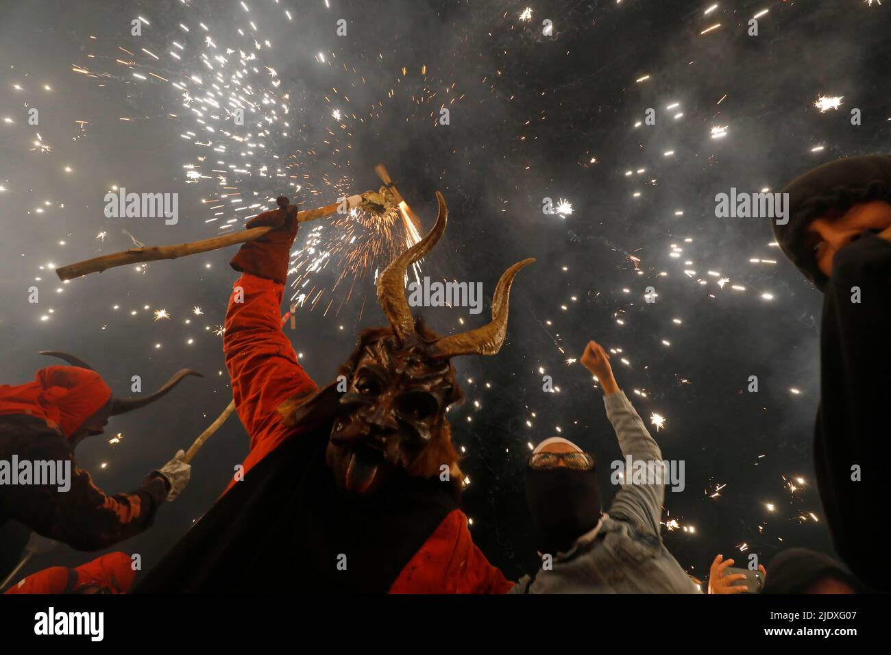 Palma, Spanien. 23.. Juni 2022. Beim traditionellen Correfoc am St. John's Eve tanzen Nachtschwärmer unter Menschen, die als Teufel gekleidet sind, während ein Feuerwerk ausgehüllt wird. Correfoc ist ein traditionelles Fest, bei dem sich Menschen, die als Teufel und „Feuertiere“ verkleidet sind, mit dem Publikum vermischen und zu Musik und Feuerwerk tanzen. Quelle: Clara Margais/dpa/Alamy Live News Stockfoto
