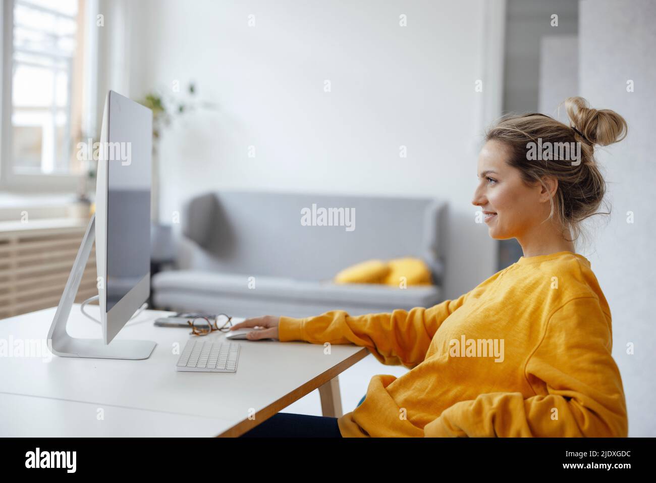Geschäftsfrau, die zu Hause einen Desktop-PC verwendet Stockfoto