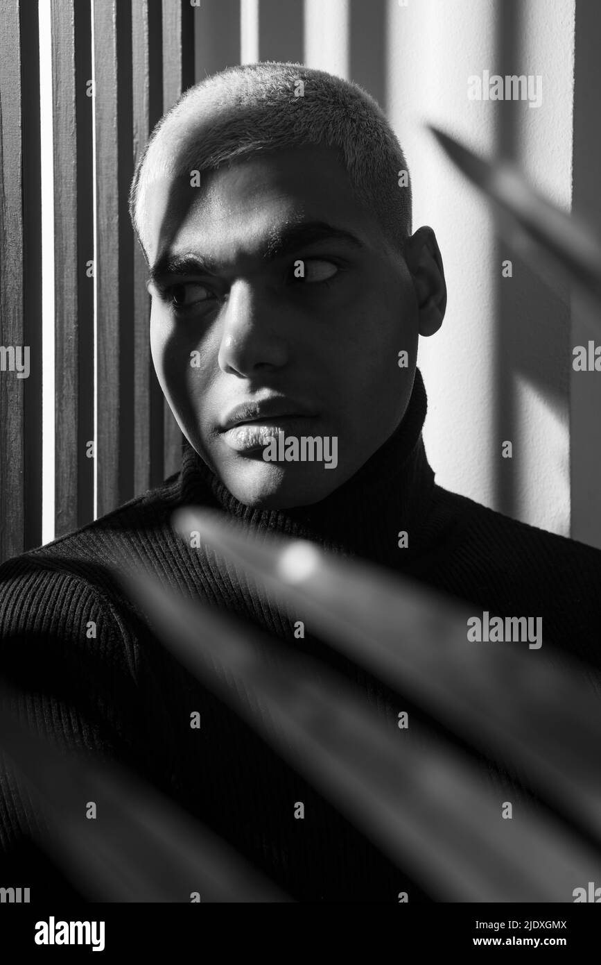 Ernsthafter Mann mit kurzen Haaren vor der Wand Stockfoto