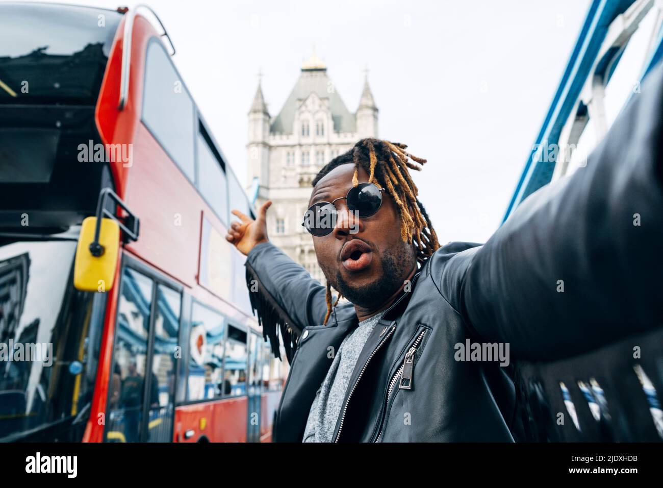 Sorgloser Mann, der inmitten von Bussen in London, England, steht Stockfoto