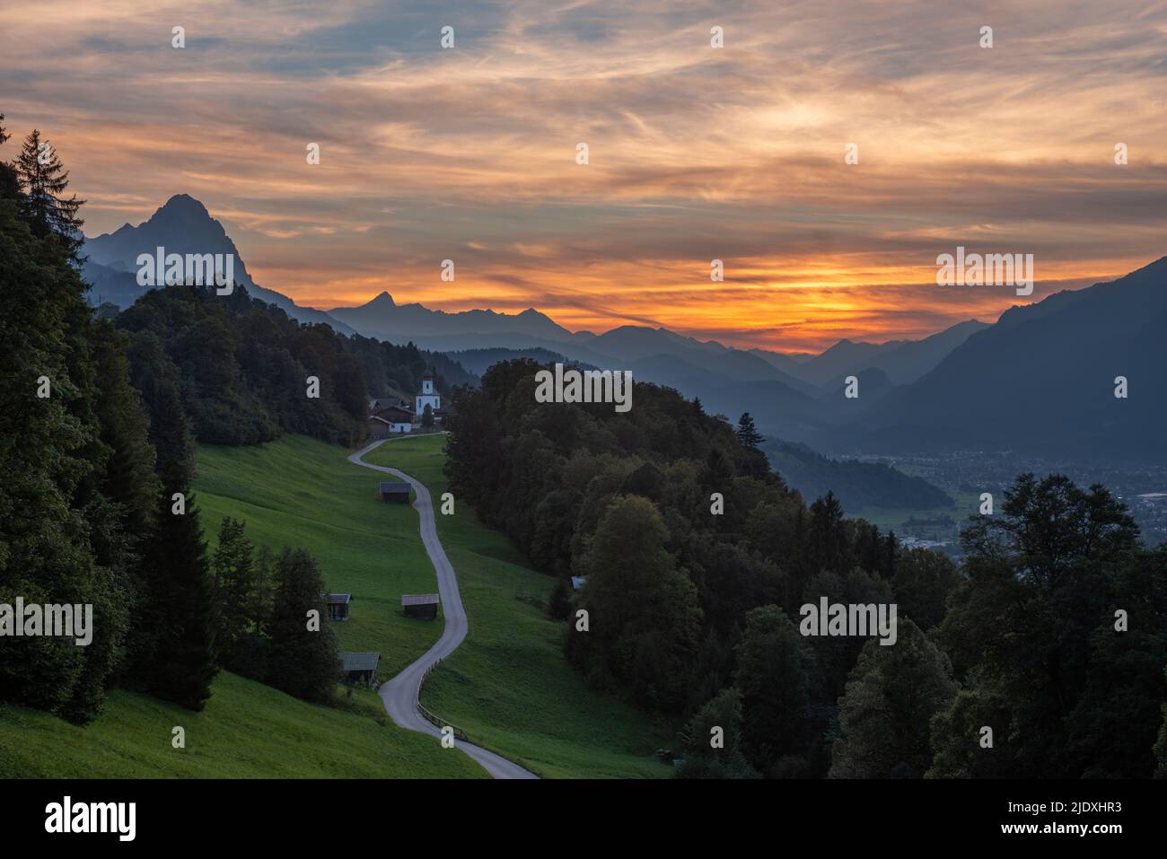 Deutschland, Bayern, Wamberg, Straße, die in die abgelegene Ortschaft in den Wettersteingebirge in der Abenddämmerung führt Stockfoto